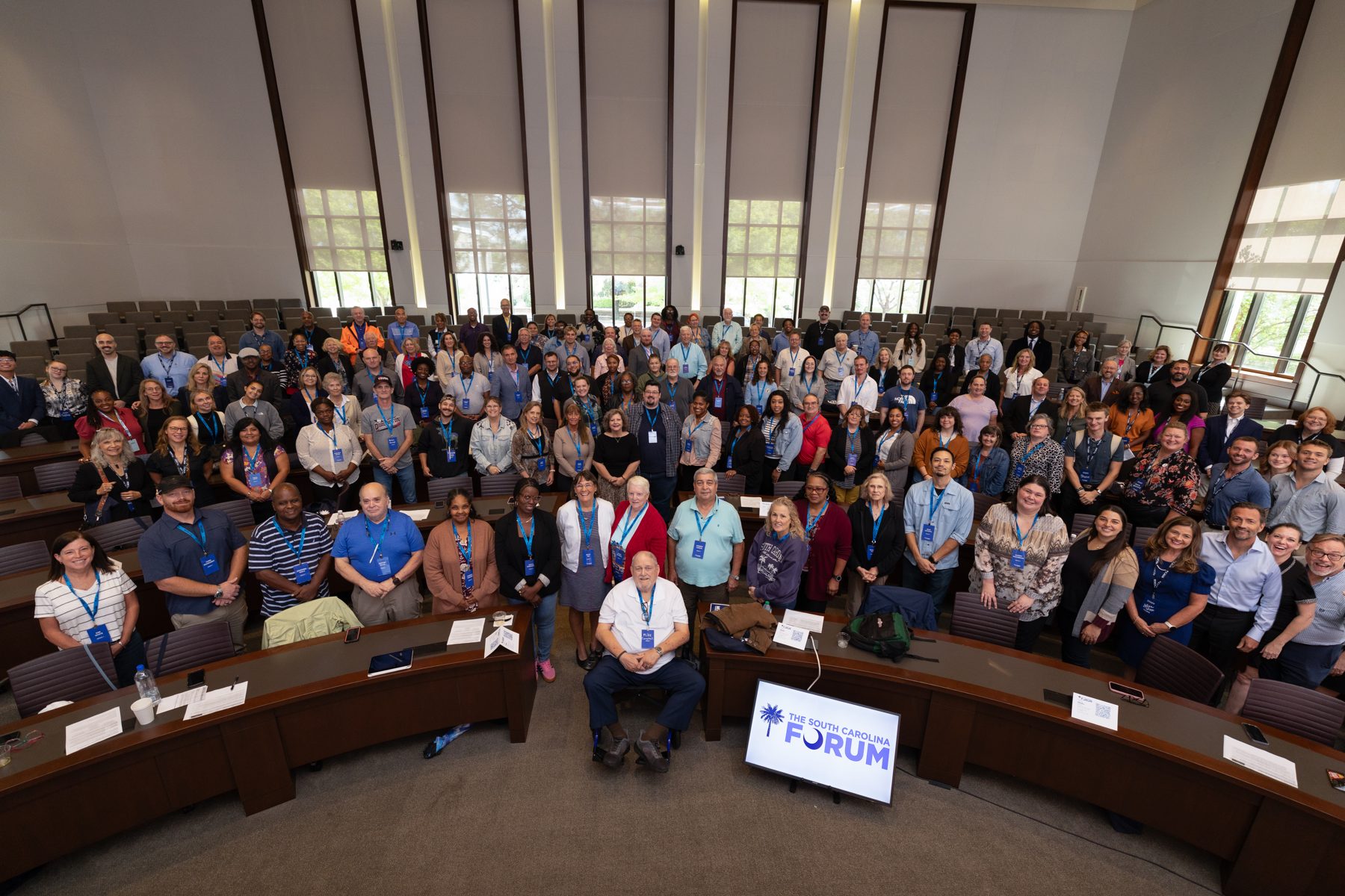 Group photo of the Civic Assembly delegates in the chamber, gathered around a South Carolina Forum screen